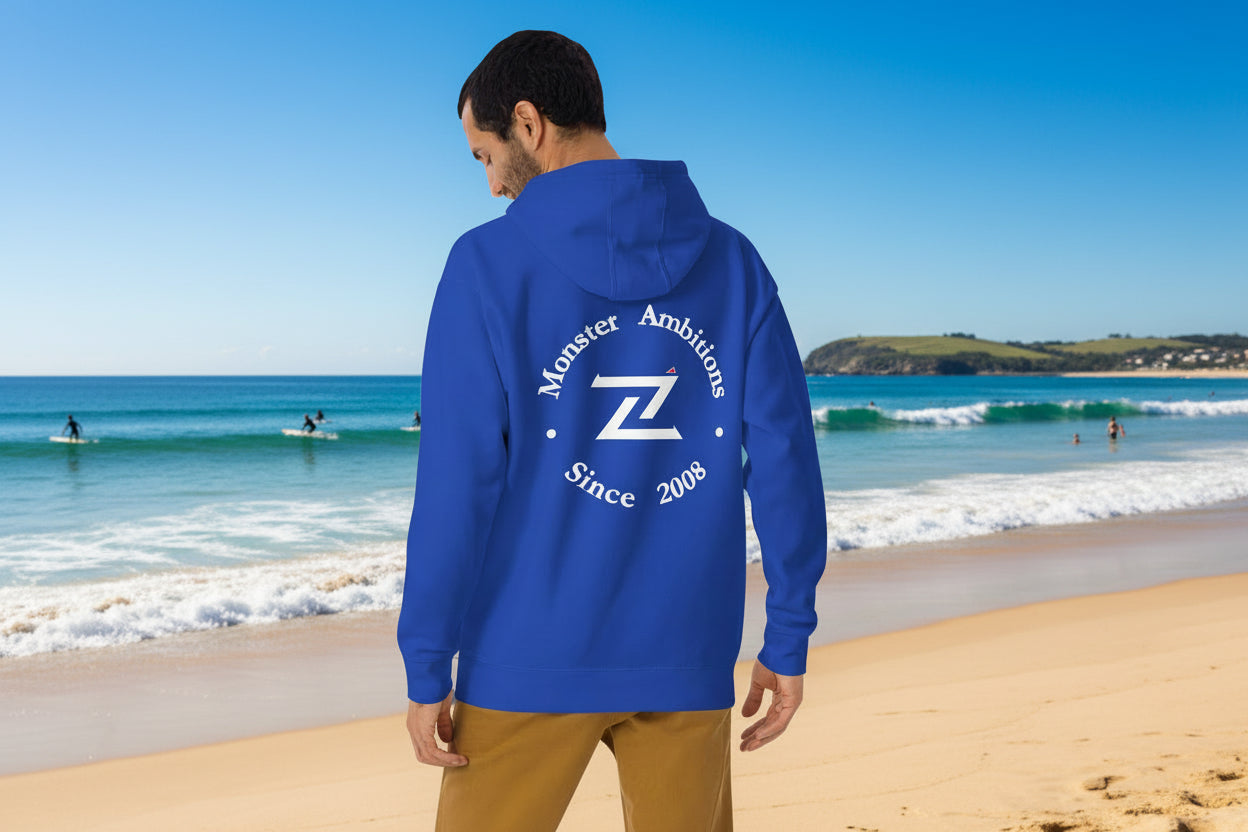 A man wears the Zilla Monster Ambitions Hoodie at a popular surfing venue.